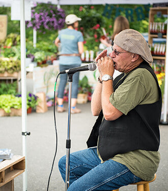 Man with microphone and harmonica at westport farmers market