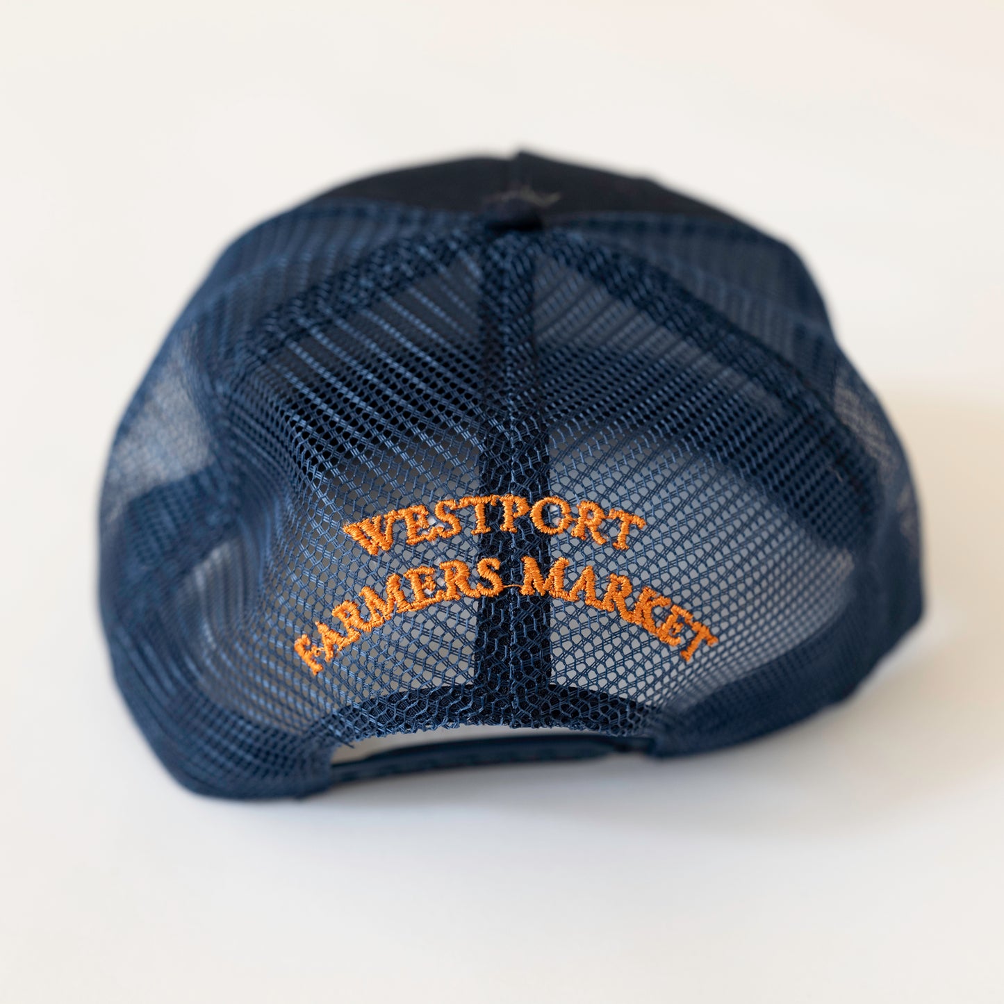 Navy baseball hate with orange text on back that says westport farmers market