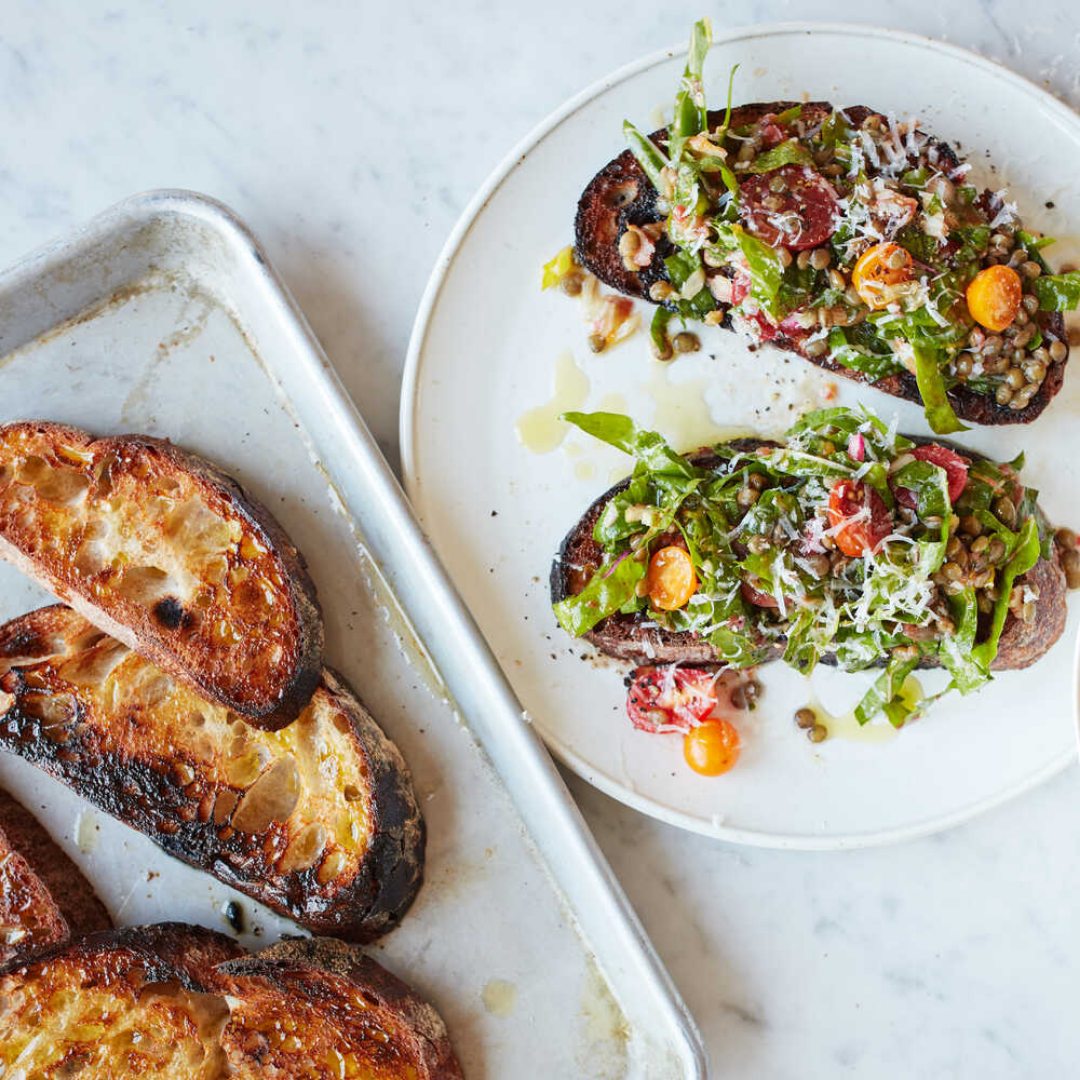 toast with tomatoes and greens on white plate
