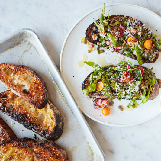 toast with tomatoes and greens on white plate
