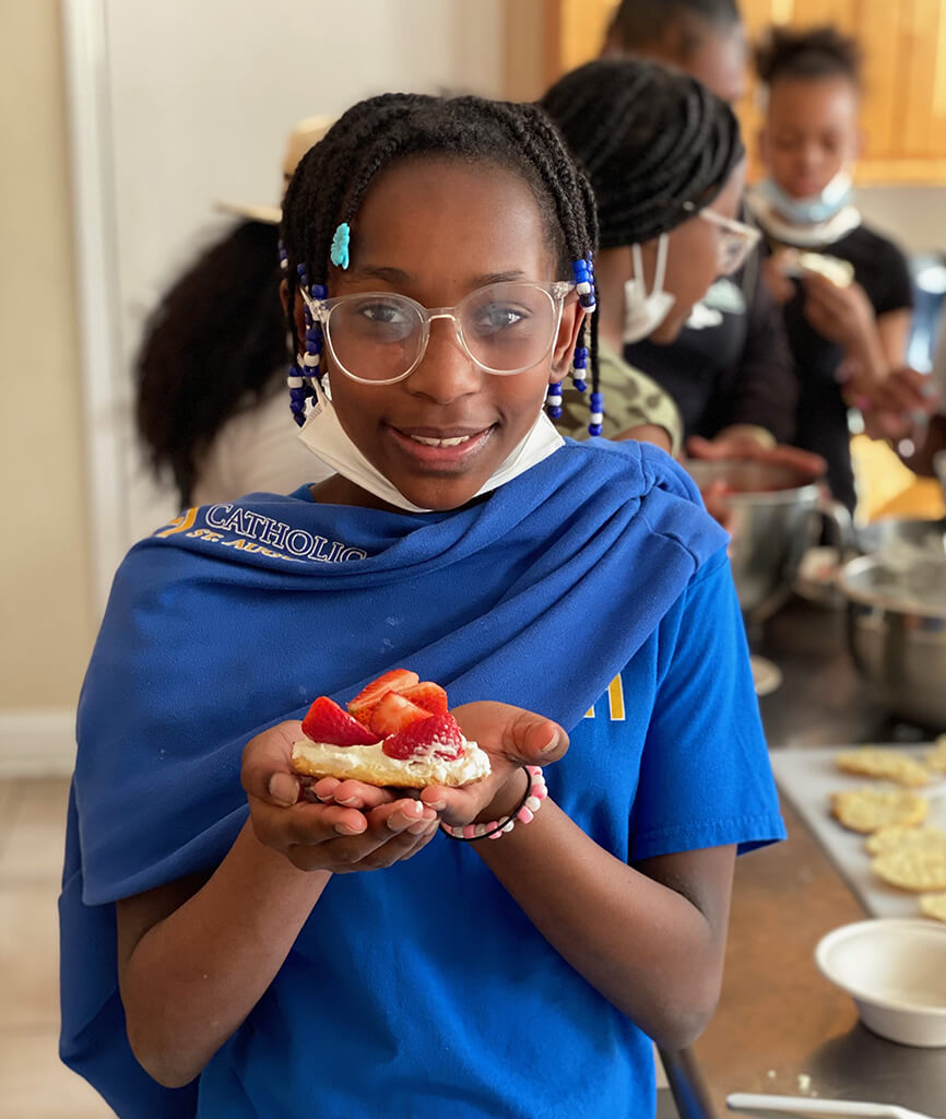 young girl holding strawberry desert