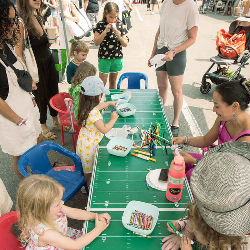 children with crayons on table at event